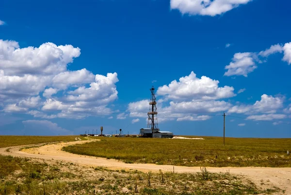 Torre di petrolio tra campi — Foto Stock