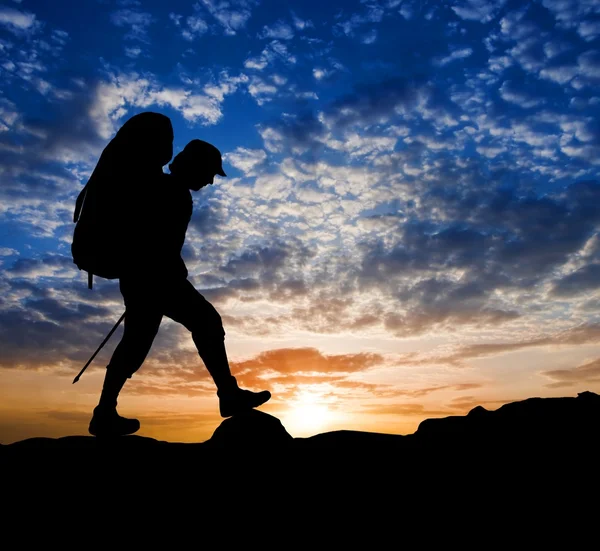 Hiker silhouette on a sunset background — Stock Photo, Image