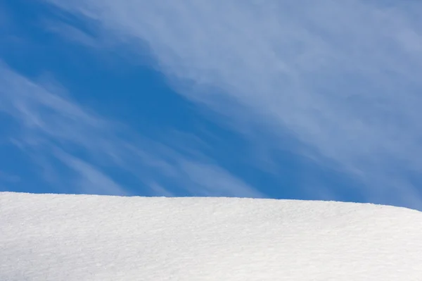 Синее небо и снежный холм — стоковое фото
