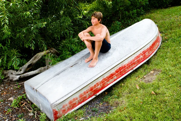 Nastolatek na siedzi na łodzi — Zdjęcie stockowe