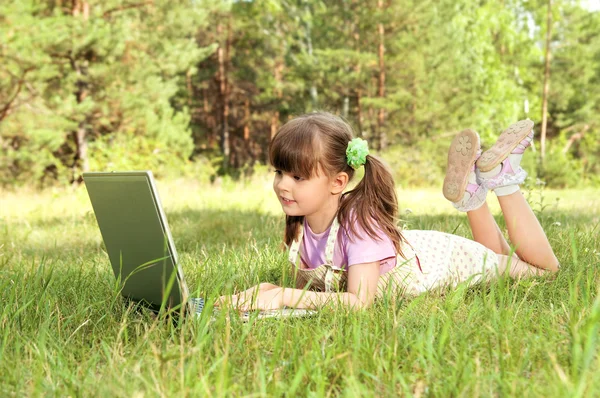 Маленька дівчинка з комп'ютером — стокове фото