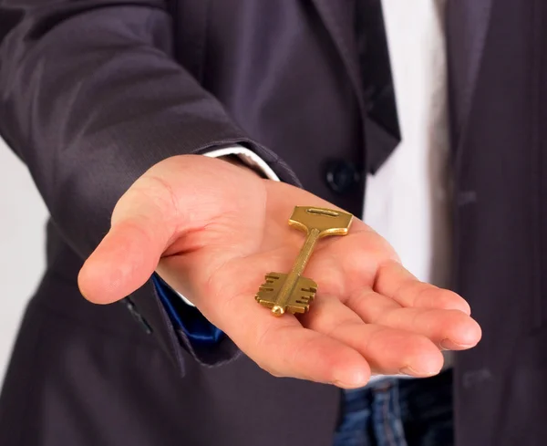 Empresário com uma chave de casa na mão isolado em branco — Fotografia de Stock
