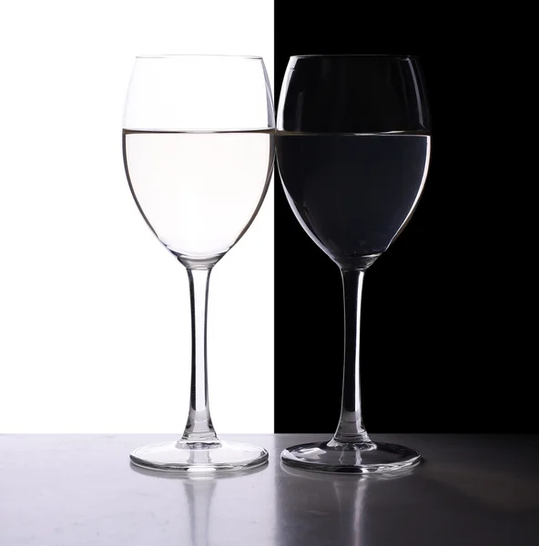검은 색 과 흰색의 대조적 인 배경 위에 백라이트가 놓인 포도주 잔 두 개 — 스톡 사진