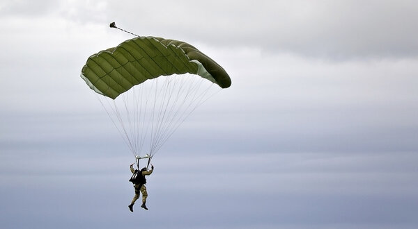 Military parachutist on the background of dark sky