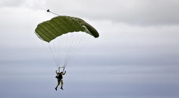 Paracadutista militare sullo sfondo del cielo scuro Fotografia Stock