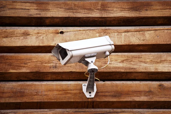 Camera on a wall of wooden houses — Stock Photo, Image