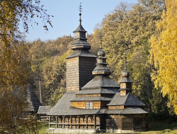 stock image Old wooden church in the background of the autumn landscape