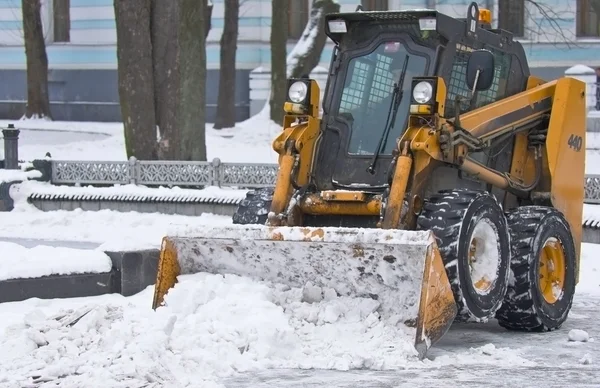 Traktor rensar snö på stadens gator — Stockfoto