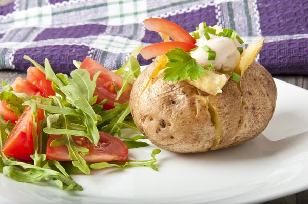 Gebakken aardappel gevuld met zure room en rucola — Stockfoto