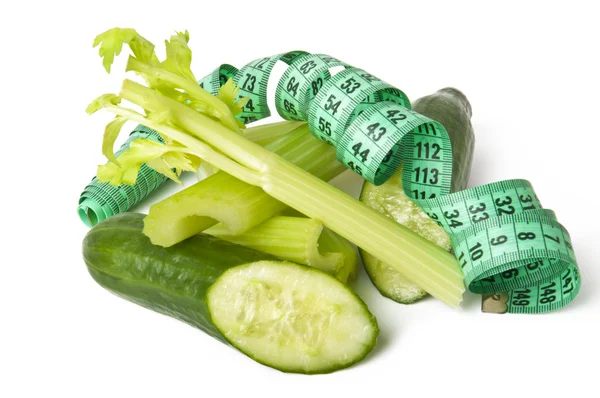Diet concept. cucumbers and celery green with measure tape — Stock Photo, Image