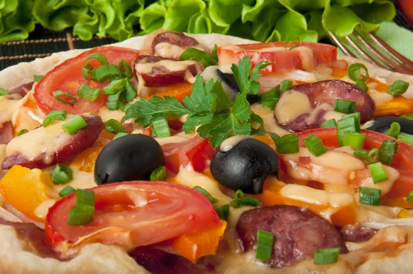 Fechar a piza com tomates, queijo, azeitonas pretas e pimentas — Fotografia de Stock