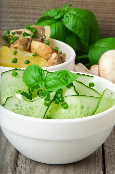 Картофель с грибами и огуречным салатом с зеленым луком и базиликом — стоковое фото