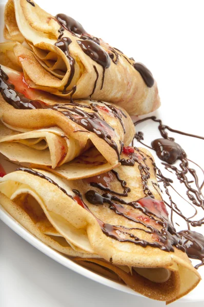 Pancakes with chocolate and strawberry syrup — Stock Photo, Image