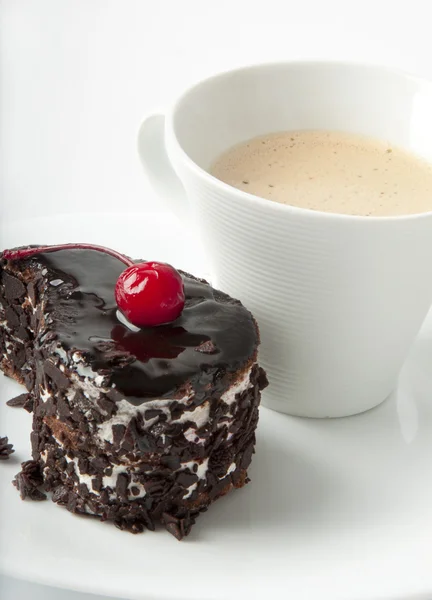 Чашка кофе и шоколадный десерт с вишней — стоковое фото
