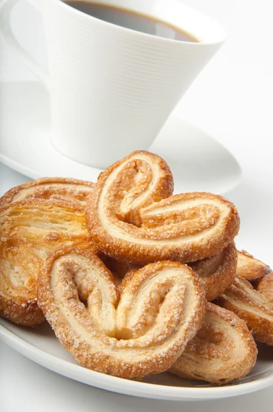 Biscoitos de pastelaria escamosa e uma xícara de café — Fotografia de Stock