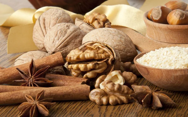 Wood nut, walnut, anise, cinnamon and sesame against a dark background — Stock Photo, Image