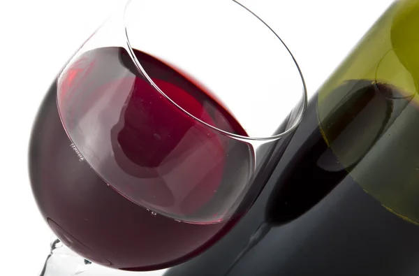 Glas en fles rode wijn op witte achtergrond. — Stockfoto