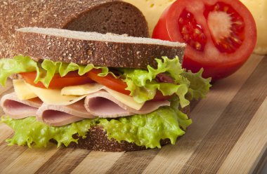 Healthy ham sandwich with cheese, tomatoes and lettuce clipart