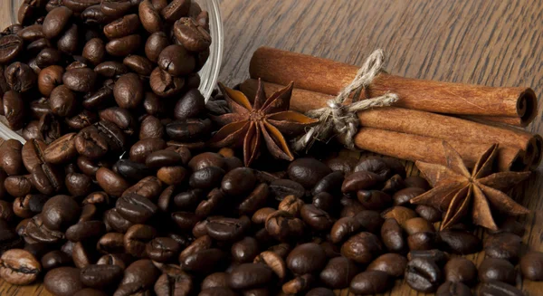Zrna kávy a koření na dřevěné pozadí — Stock fotografie