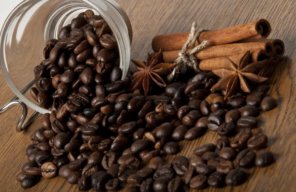 Zrna kávy a koření na dřevěné pozadí — Stock fotografie