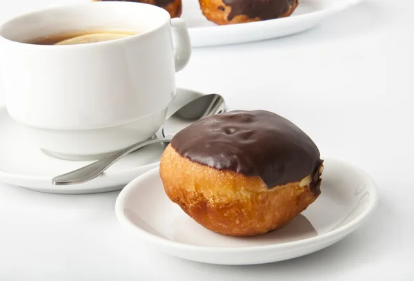 Donut with chocolate and a cup of tea on a white background — Stock Photo, Image