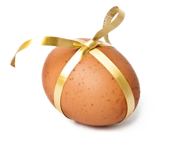 Uovo di Pasqua con un nastro d'oro isolato su bianco — Foto Stock