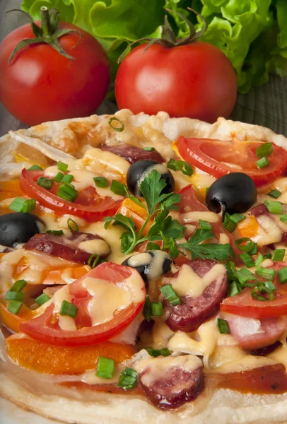 Närbild av pizza med tomater, ost, svarta oliver och paprika. — Stockfoto