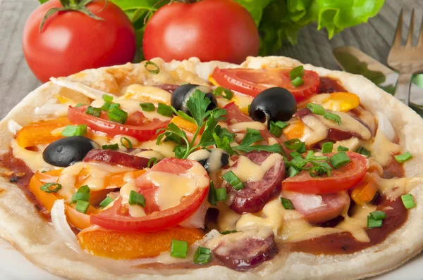 Close-up van pizza met tomaten, paprika, kaas en zwarte olijven. — Stockfoto