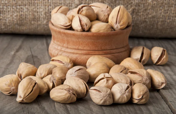 Roasted pistachios on a natural wooden background — Stock Photo, Image