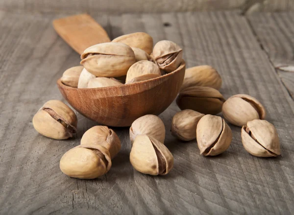 Gebarsten en gedroogde pistache noten in een houten lepel — Stockfoto
