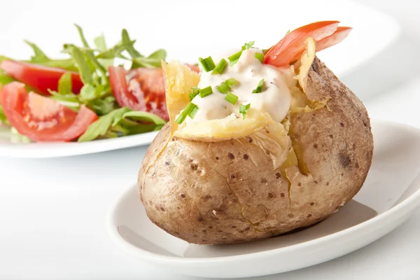 Patata al horno llena de crema agria y rúcula —  Fotos de Stock