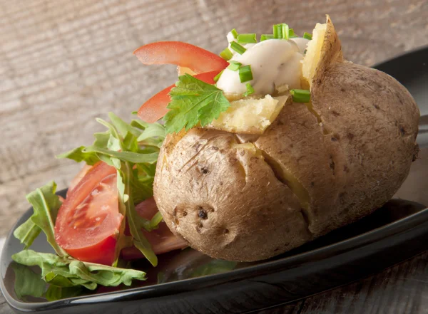 Baked potato filled with sour cream and arugula — Stock Photo, Image