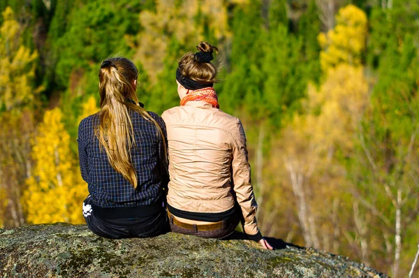 Dwie dziewczyny siedzi na skale — Zdjęcie stockowe