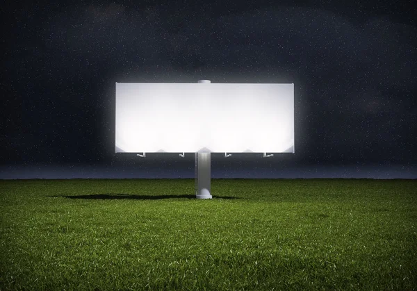 Ad billboard standing in a field of grass - night version — Stock Photo, Image