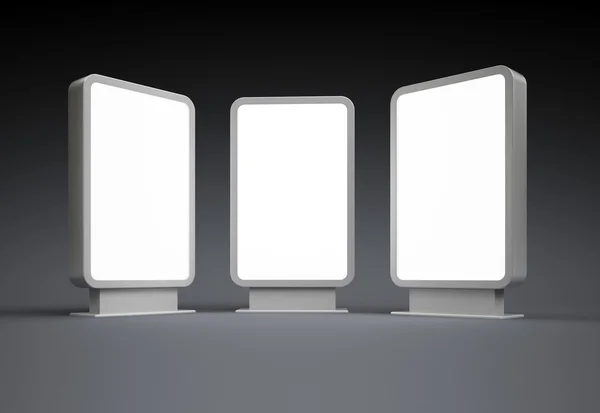 Tre luminosi cartelloni luminosi verticali in bianco di notte — Foto Stock