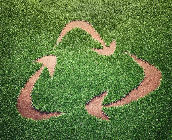 Símbolo de reciclagem em um campo de grama — Fotografia de Stock