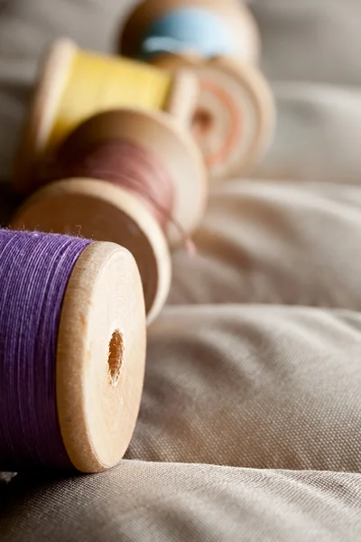 Thread bobbins on a gray fabric — Stock Photo, Image