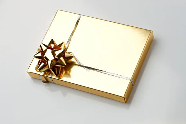 Boîte cadeau avec un arc doré — Photo