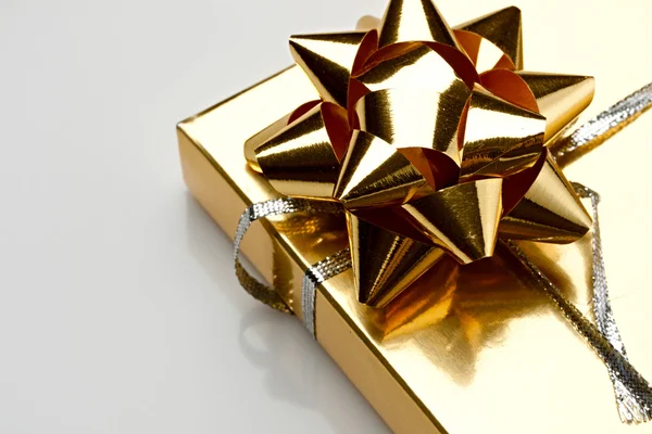 Gift box with a golden bow — Stock Photo, Image