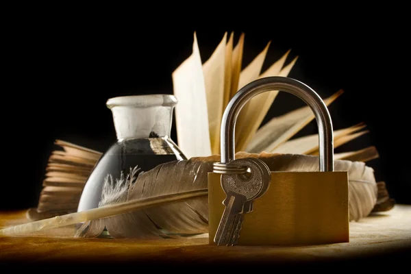 Une plume, un pot d'encre, un vieux livre et un porte-clés — Photo