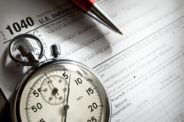 Φορολογική μορφή, κόκκινο στυλό και χρονόμετρο — Φωτογραφία Αρχείου