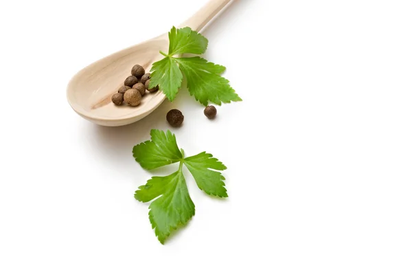 Pepper in a wooden spoon and parsley — Stock Photo, Image