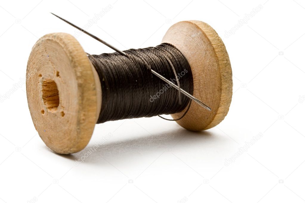 Needle and Bobbin with Black Thread on Black Background Stock