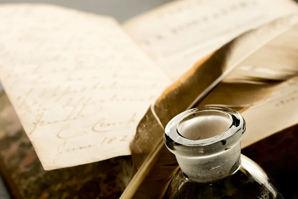 Old book with feather and inkpot — Stock Photo, Image