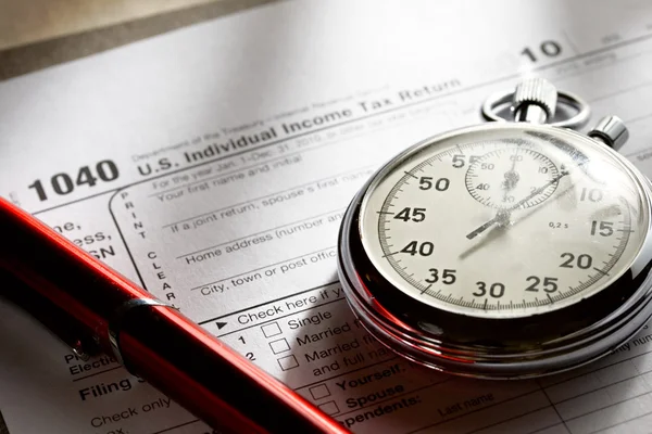 Steuerformular, roter Stift und Stoppuhr — Stockfoto