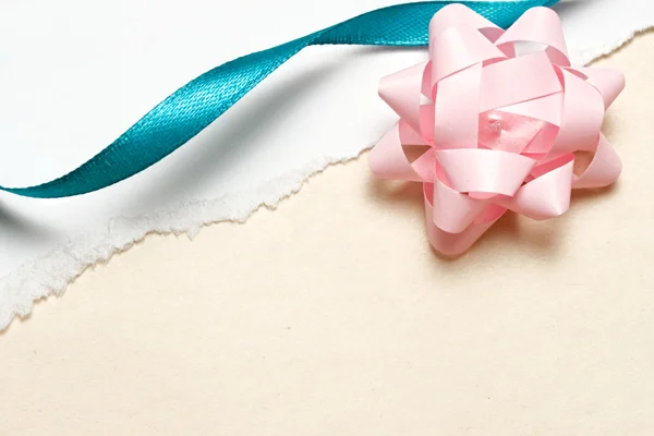 Bow and ribbon on ragged paper — Stock Photo, Image