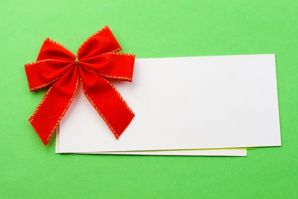 Red bow with card on green Royalty Free Stock Images