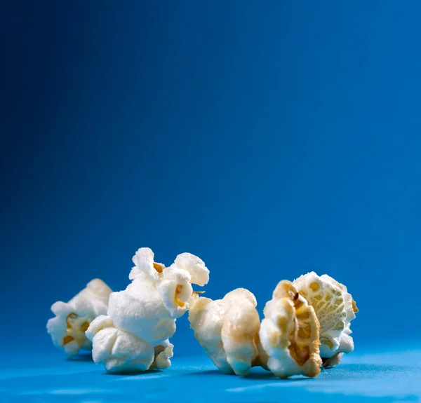 Popcorn på blå bakgrund — Stockfoto