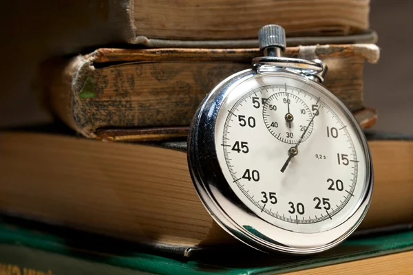 Pile of old books and stopwatch — Stock Photo, Image