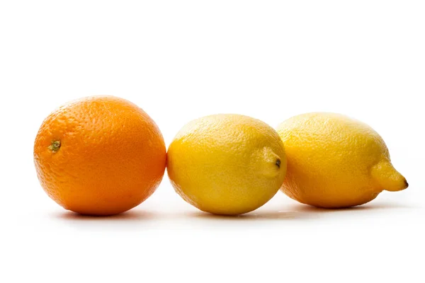Два лимона и один апельсин. — стоковое фото
